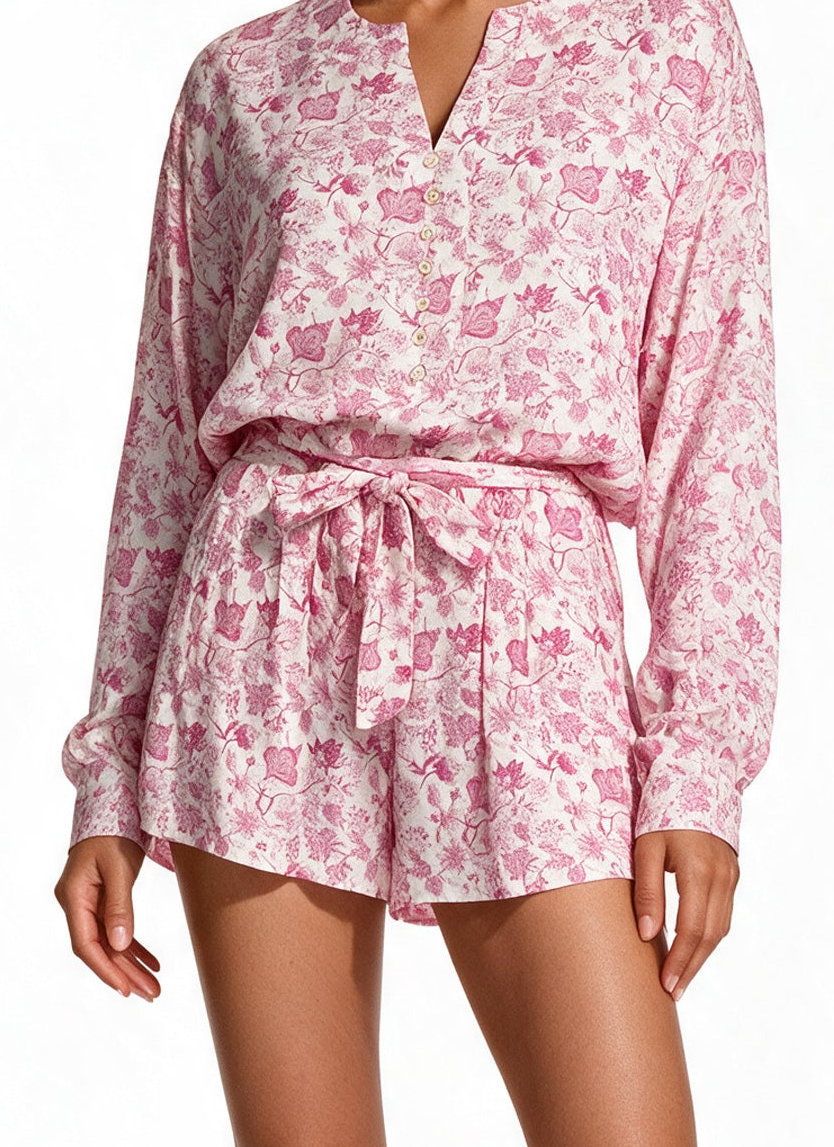 A woman wearing a pink and white short pairing with the blouse.